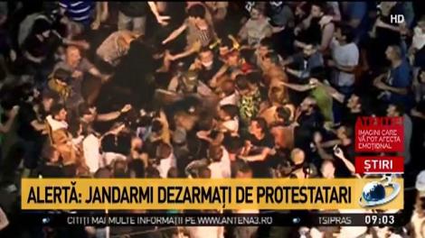 O femeie-jandarm și colegul ei, bătuți minute &icirc;n șir de protestatari