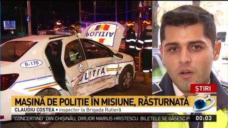 Mașină de poliție &icirc;n misiune, răsturnată &icirc;n intersecție
