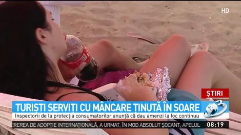 Turişti serviţi cu m&acirc;ncare ţinută &icirc;n soare